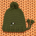 Vista completa gorro crochet verde oliva Olive Trail Pompom Edition con pompón y borlas laterales — LIA.G
