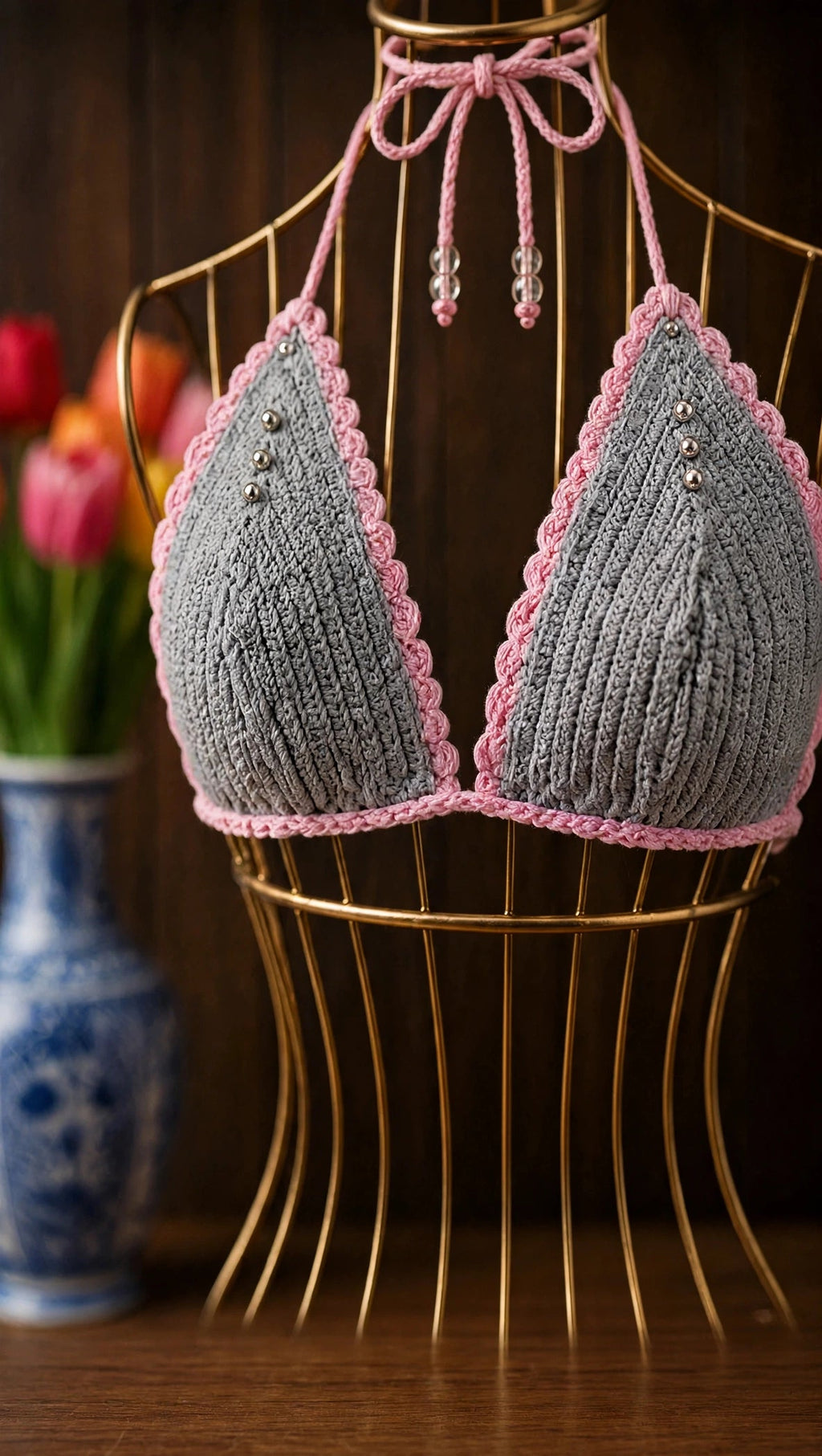 Detalle top triangular bikini crochet gris con festón rosa y cordón halter