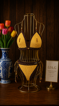 Detalle braguita bikini crochet amarillo con lazos trenzados marrón y cuentas multicolor