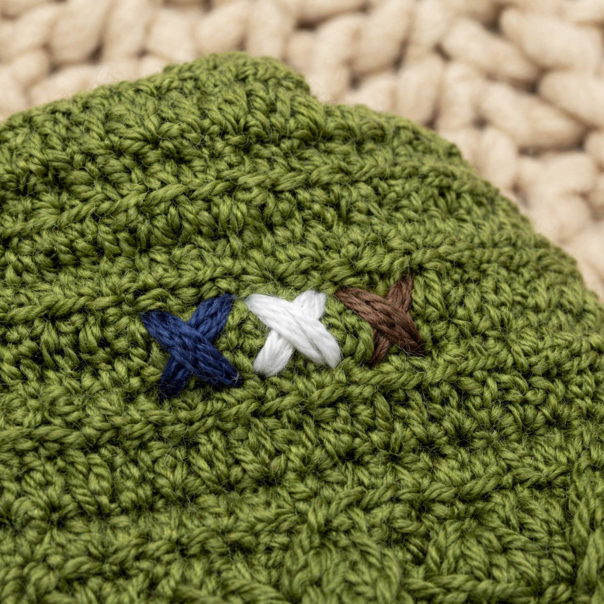 Detalle bordado 3 aspas tricolor azul marino, blanco y marrón sobre punto texturizado verde musgo — Little Olive Elf LIA.G