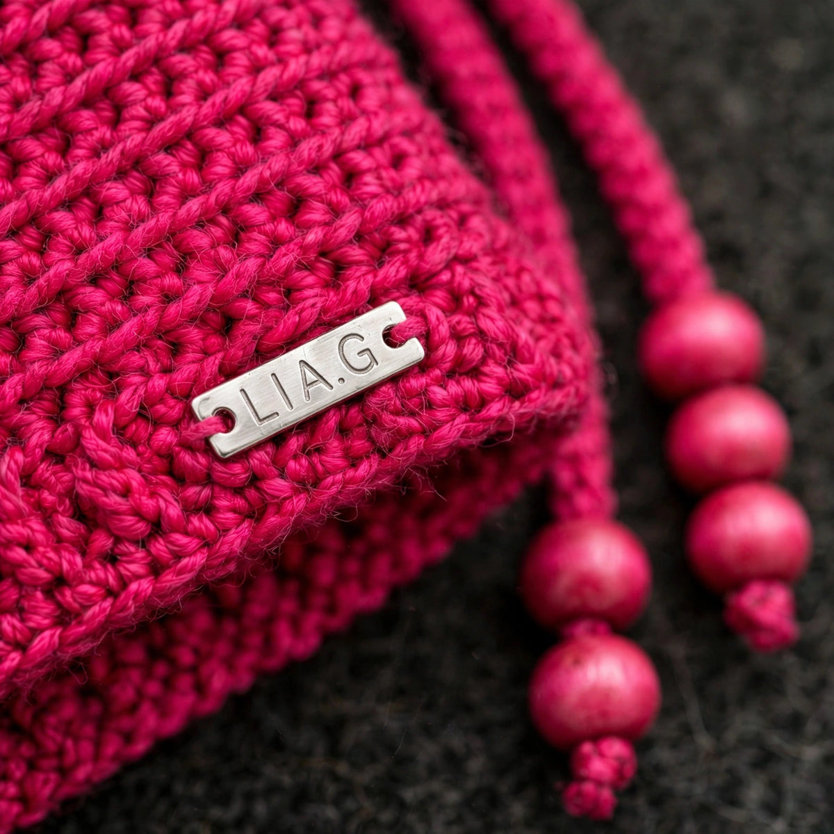 Detalle placa metálica LIA.G y textura punto bajo liso en fucsia — Magenta Bloom LIA.G