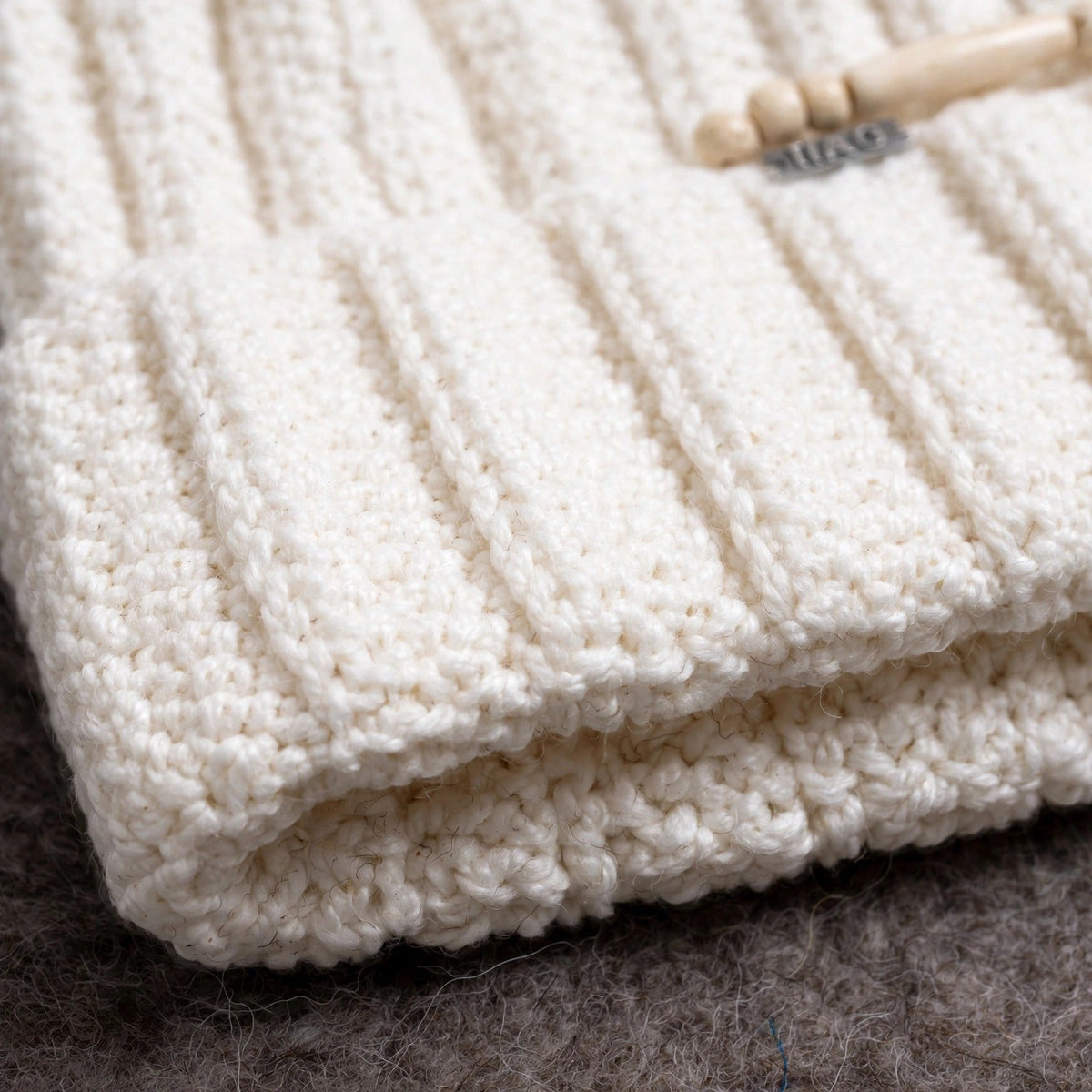 Detalle textura acanalado ribbing integral y puño vuelto fold-over crudo — Cream Cable Grey Pom LIA.G