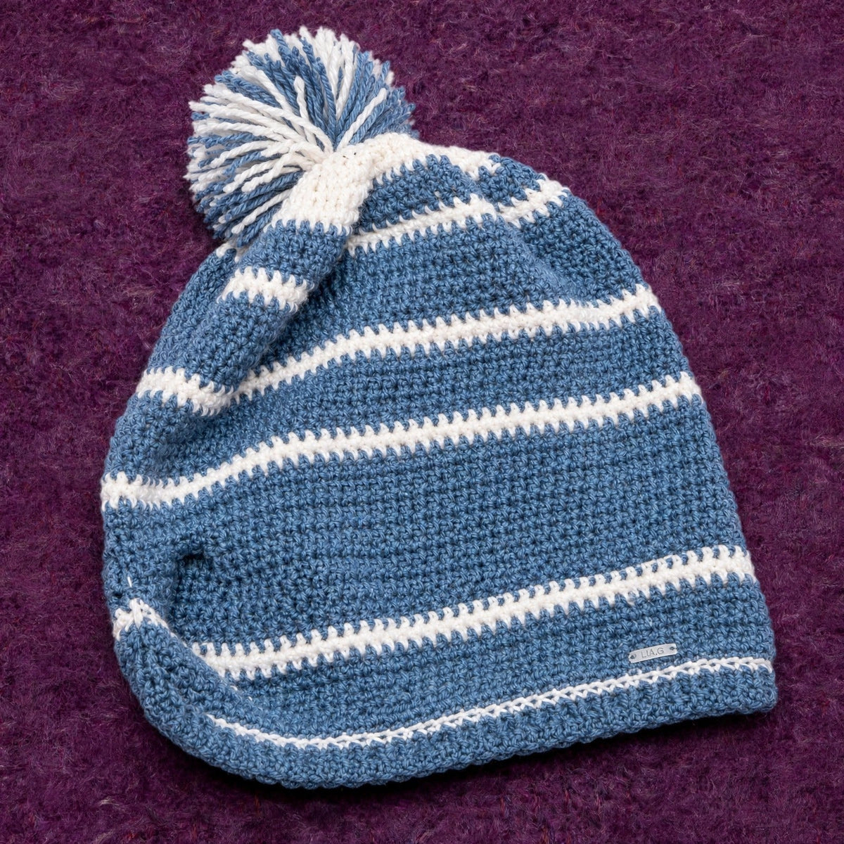 Vista completa gorro crochet slouchy azul vaquero con rayas crudo y pompón bicolor Denim Wood — LIA.G