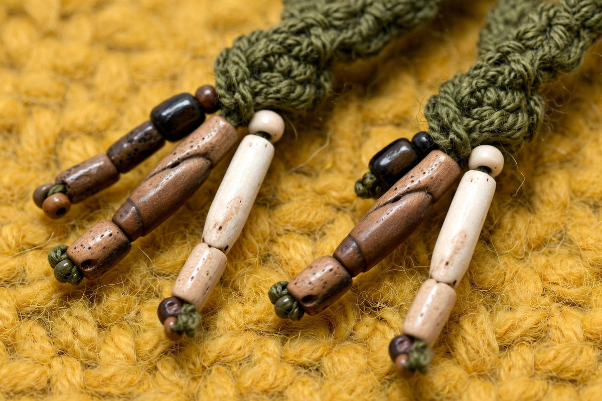 Detalle cordones trenzados con cuentas tubulares de madera y hueso en las puntas — Olive Trail LIA.G