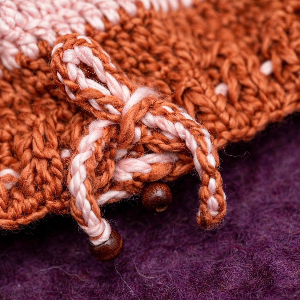 Detalle cordón trenzado bicolor rosa/terracota con cuenta de madera marrón en puño calado del gorro — Terracotta Bloom LIA.G