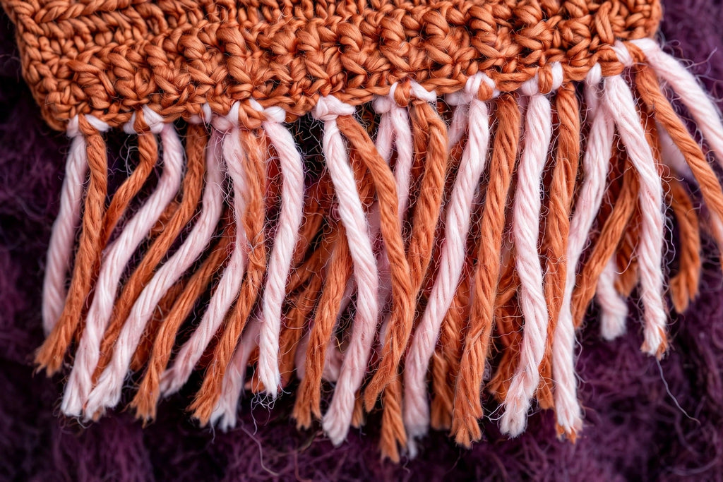 Detalle flecos largos bicolor rosa y terracota entrelazados en extremo de bufanda lana — Terracotta Bloom LIA.G
