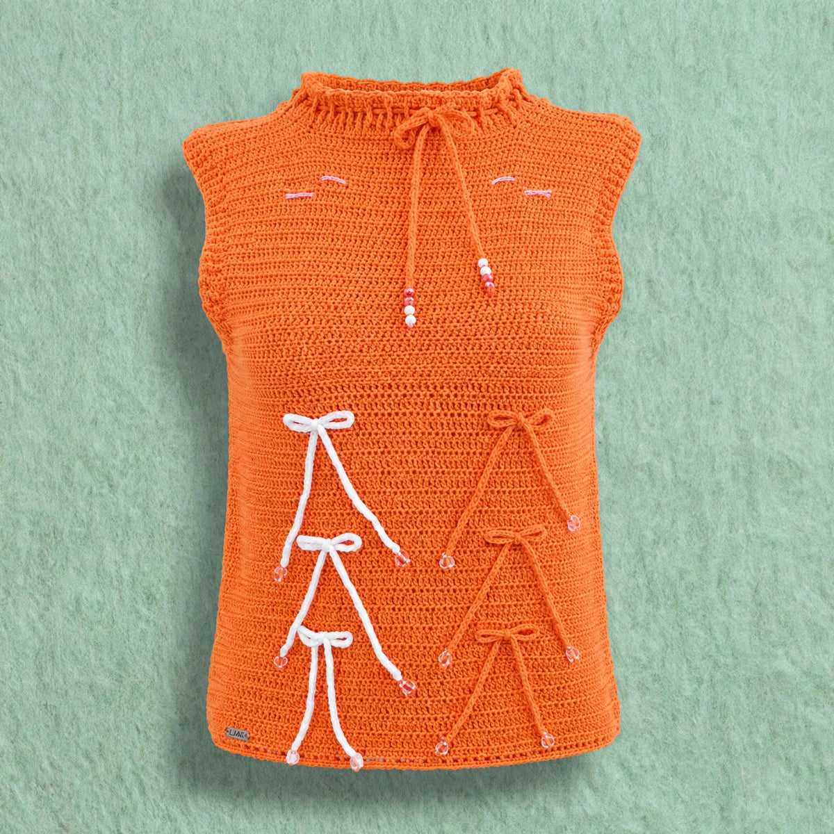 Blusa artesanal crochet naranja con lazos blancos vista completa