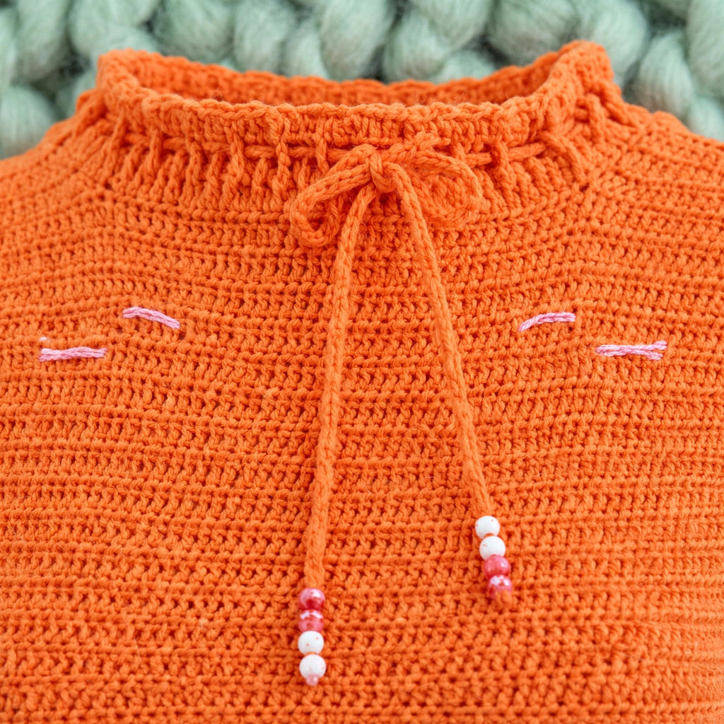 Detalle cuello alto lettuce edge con cordón y cuentas blusa crochet naranja