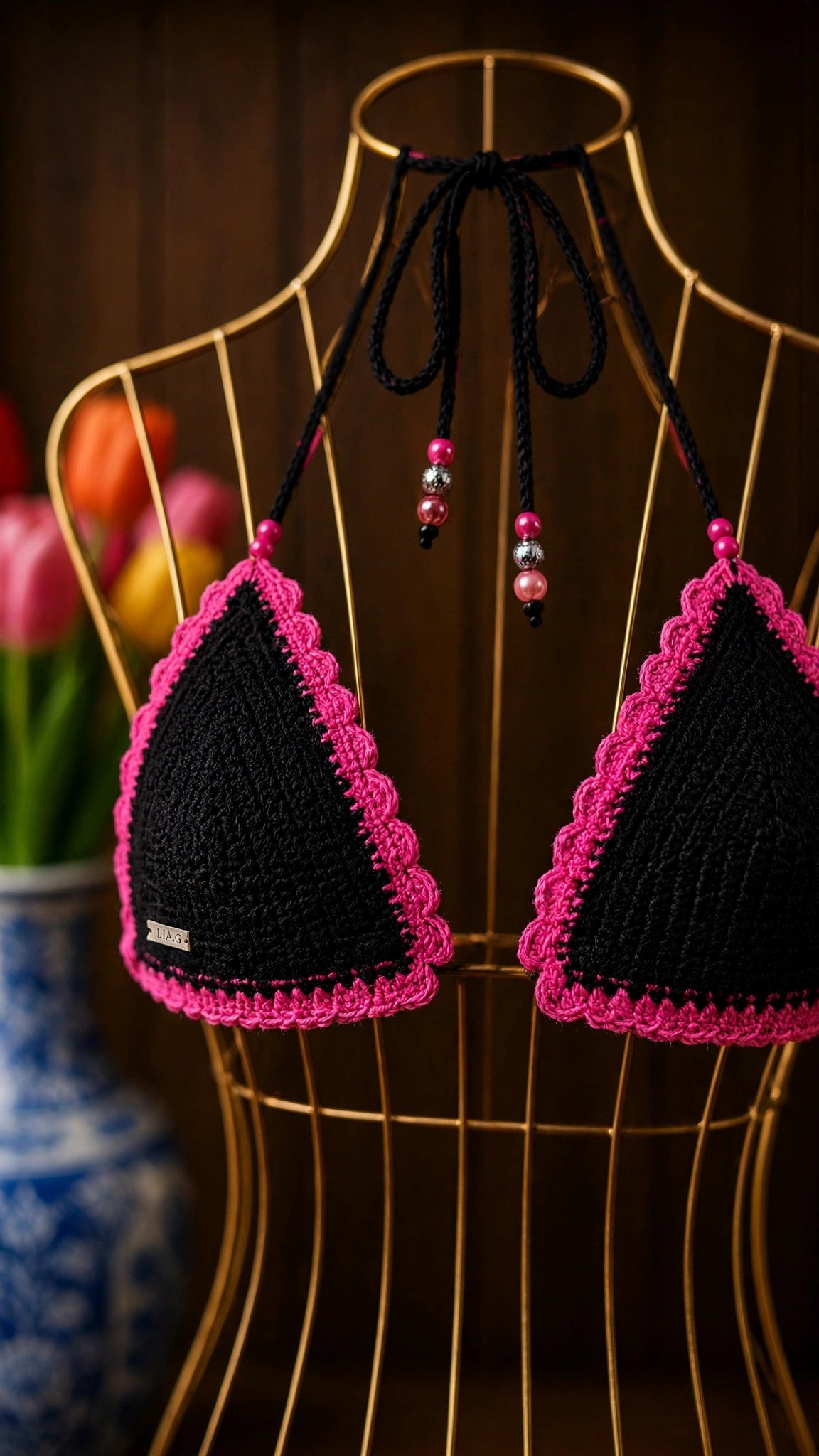 Detalle top triangular bikini crochet negro borde festoneado fucsia con cuentas