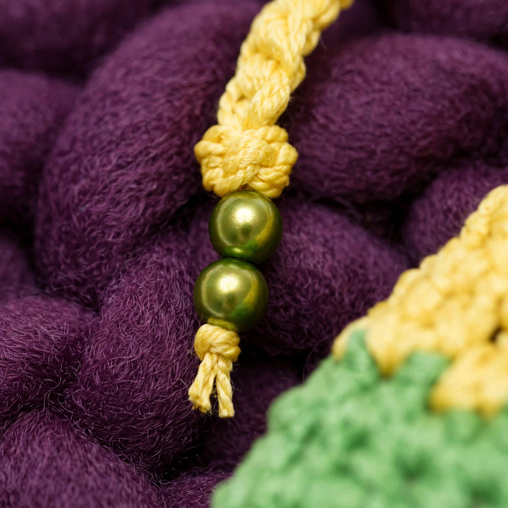 Detalle extremo cordón de cierre amarillo trenzado con 2 perlas verdes nacaradas de acabado dorado — Meadow Pouch LIA.G