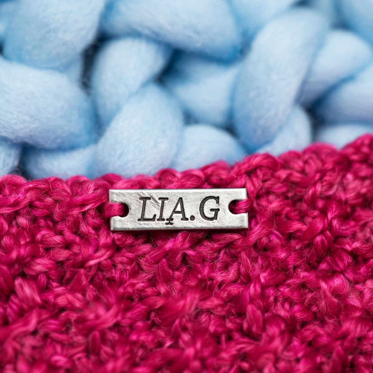 Detalle placa metálica LIA.G sobre textura punto musgo fucsia — Little Whiskers Baby Pink LIA.G