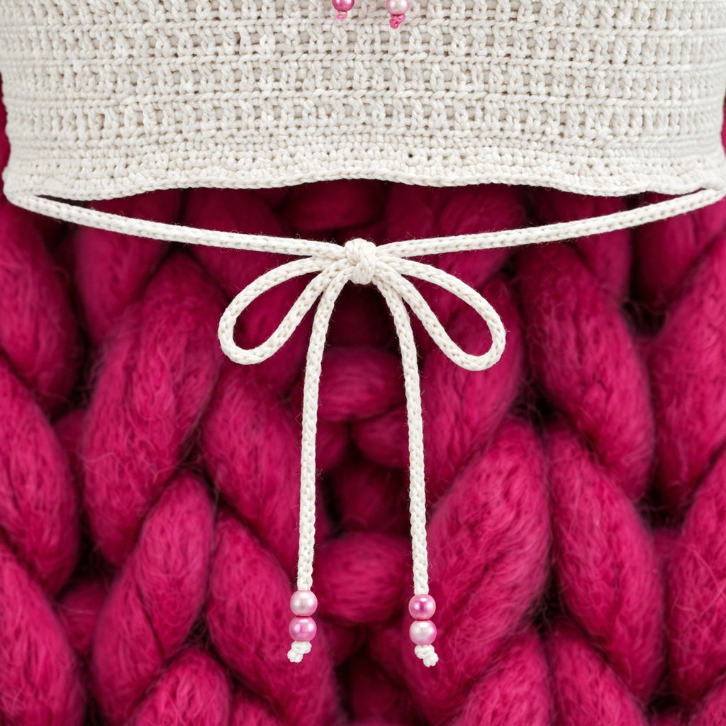Detalle cordón cinch del bajo con lazo blanco y cuentas de perla rosa — Top Crochet Crudo LIA.G