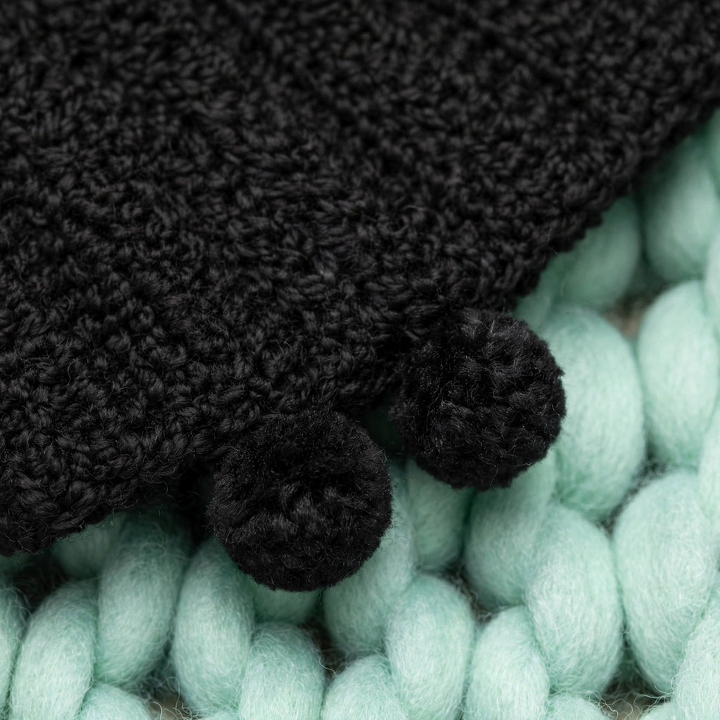 Detalle mini pompones tejidos negros en las esquinas de la bufanda extra larga — Noir Wrap LIA.G