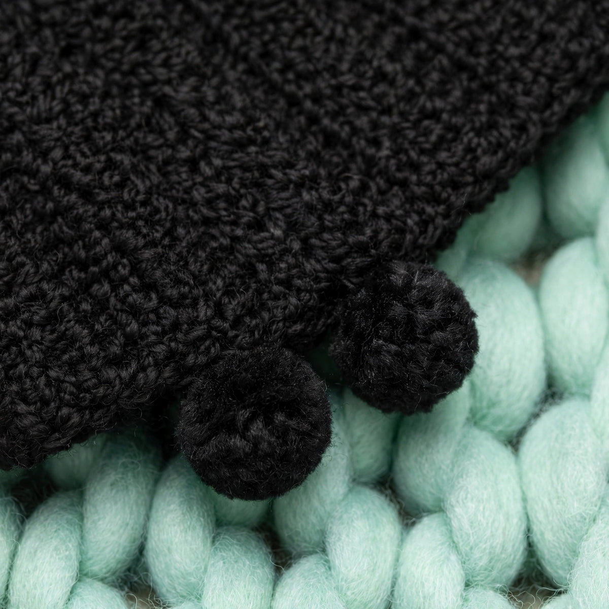 Detalle mini pompones tejidos negros en las esquinas de la bufanda extra larga — Noir Wrap LIA.G
