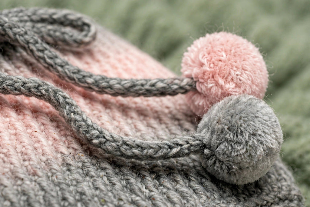 Detalle cordón trenzado gris con pompón bicolor rosa y gris en braga de cuello ajustable — Blush Fade LIA.G