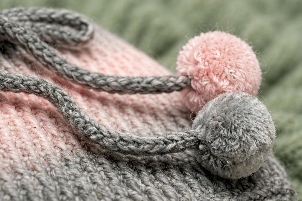 Detalle cordón trenzado gris con pompón bicolor rosa y gris en braga de cuello ajustable — Blush Fade LIA.G
