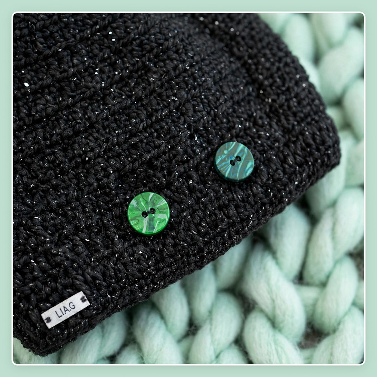 Detalle 2 botones esmaltados verde y negro sobre punto bajo liso negro brillante y placa LIA.G — Midnight Cape