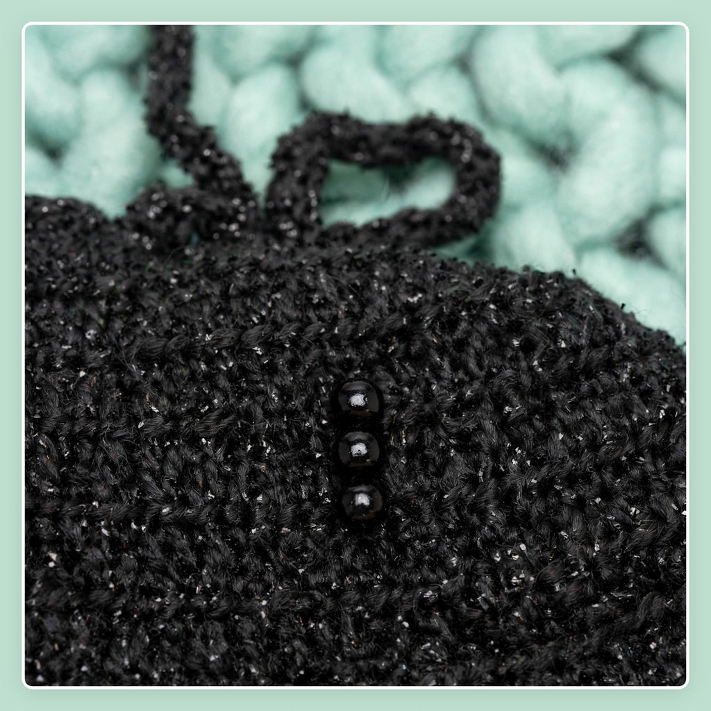 Detalle grupos de cuentas negras en extremo inferior de la capa con destello plateado — Midnight Cape LIA.G