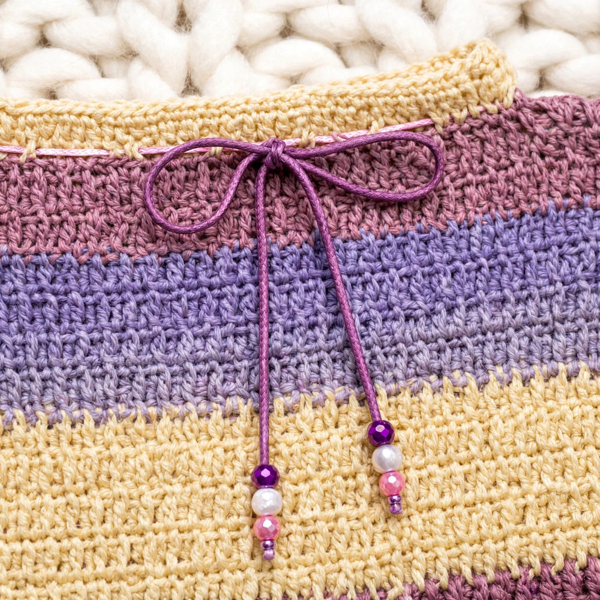 Detalle lazo cordón morado en cuello redondo amarillo mantequilla con cuentas de perla multicolor — Dusk Stripes LIA.G