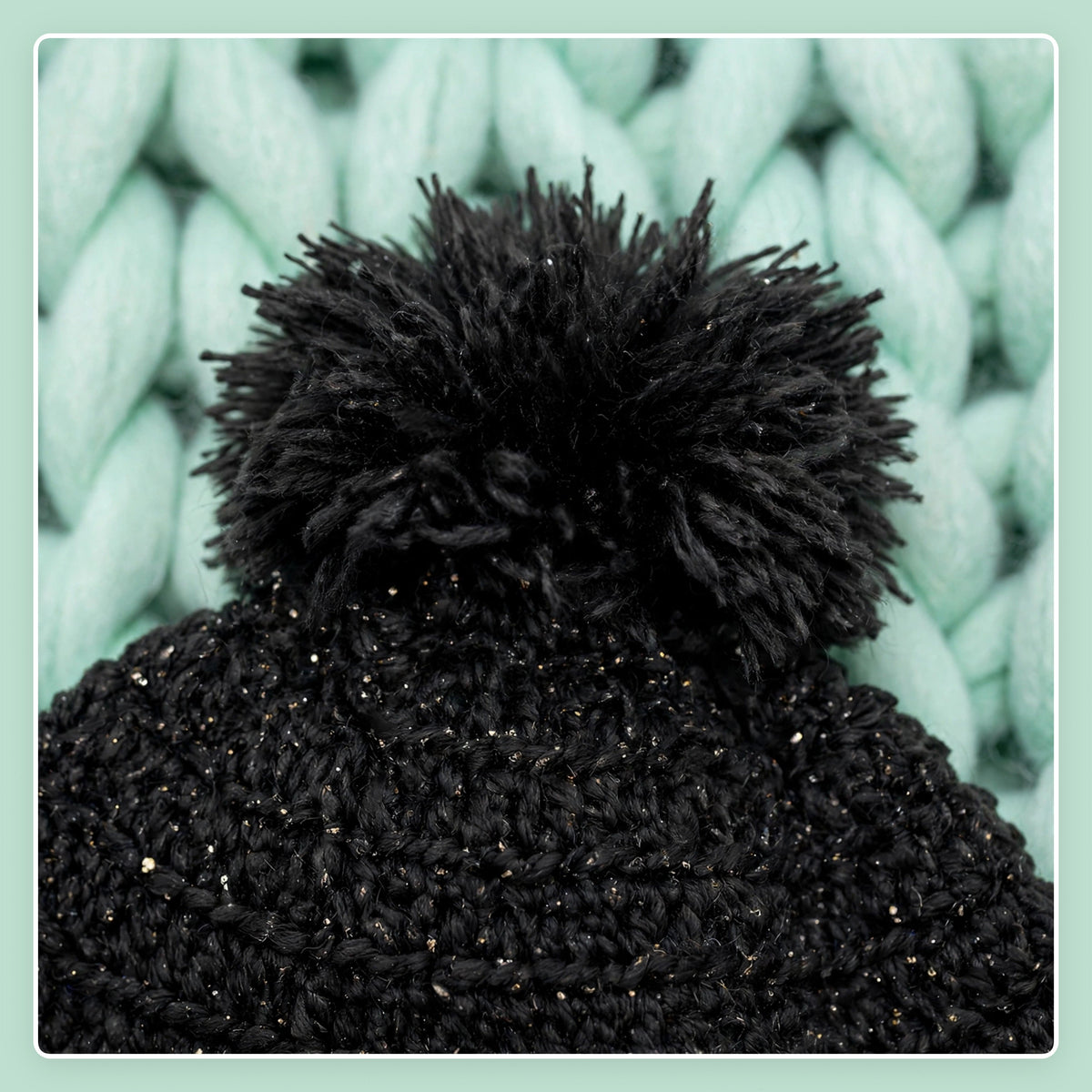 Detalle macro pompón negro peludo con destellos lurex sobre coronilla — Midnight Cape LIA.G