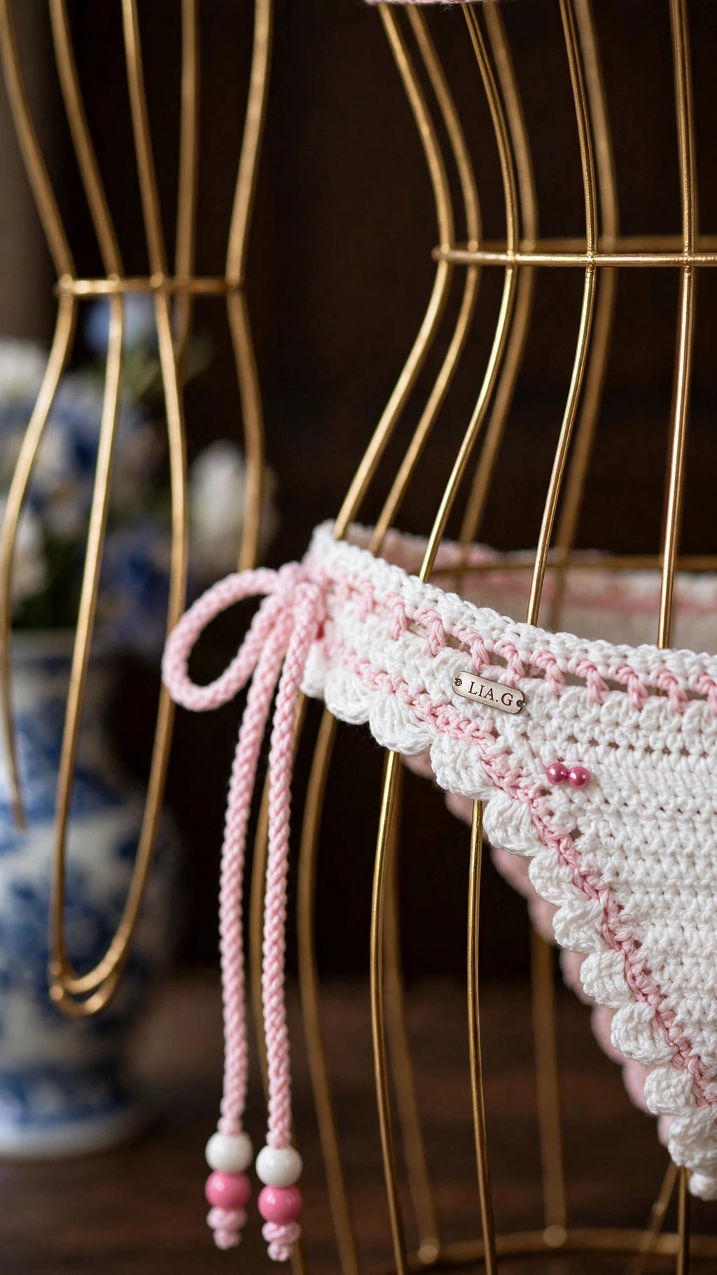 Detalle braguita bikini crochet blanco con lazos y perlas rosas