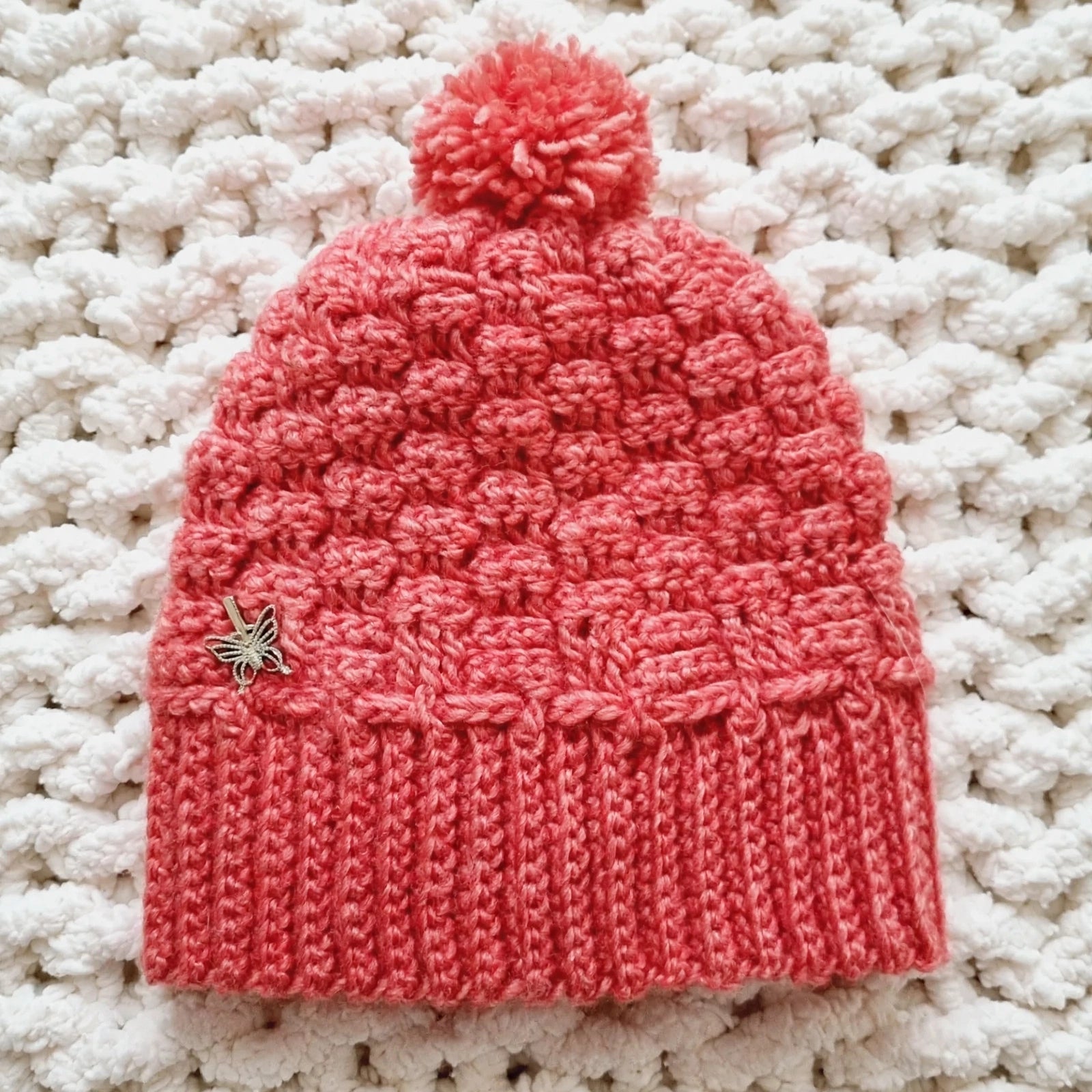 Gorro crochet rosa coral con pompones en relieve y mariposa dorada - LIA.G
