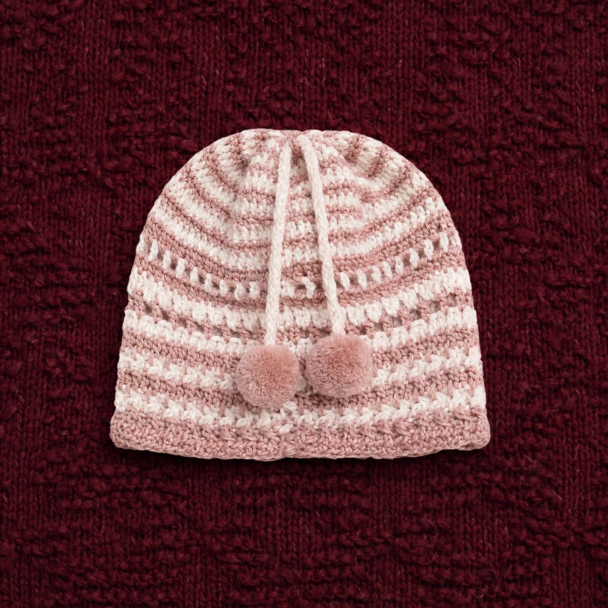 Gorro artesanal crochet Blush Bloom rosa empolvado con rayas crudo y pompones