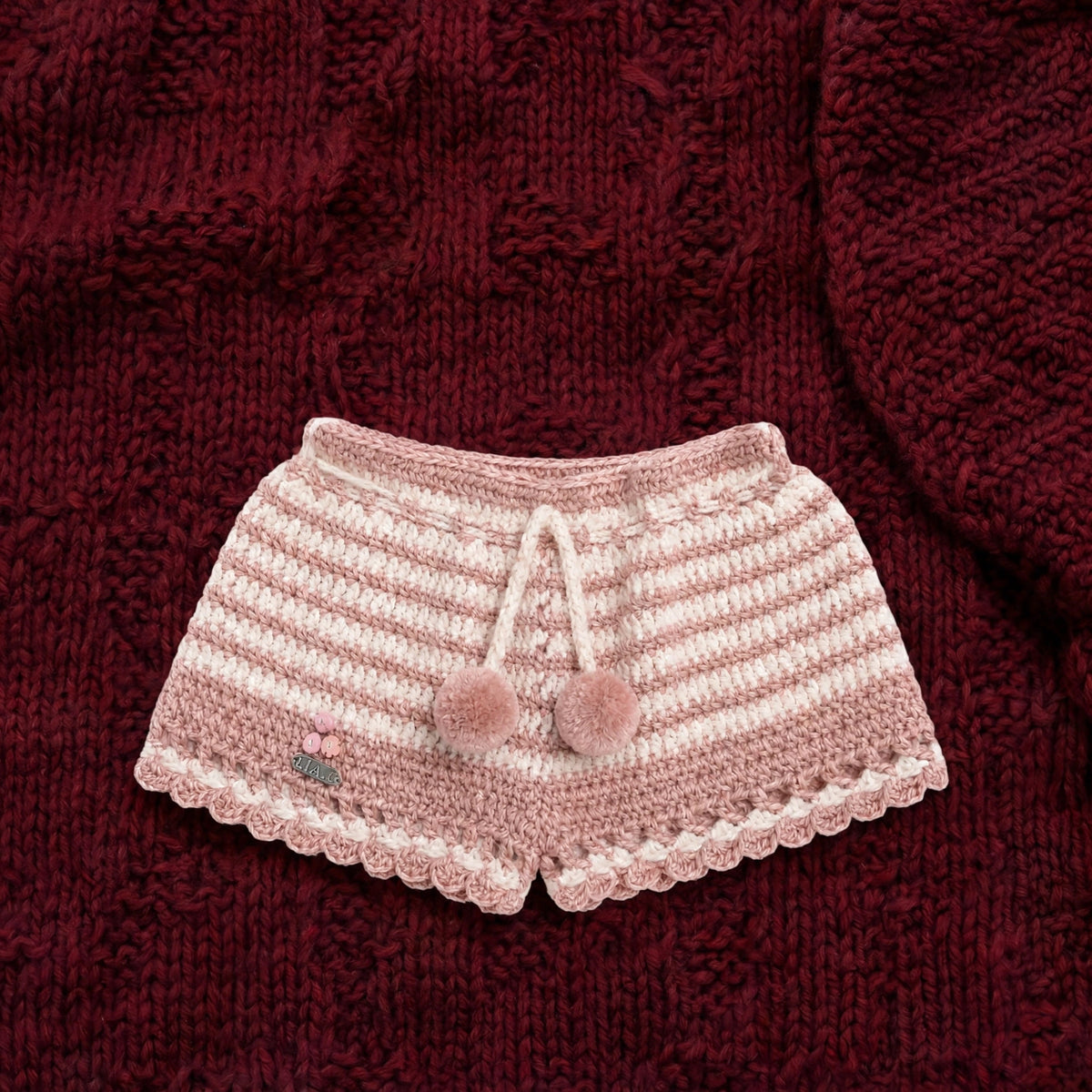 Short artesanal crochet Blush Bloom rosa empolvado con bajo festoneado y pompones