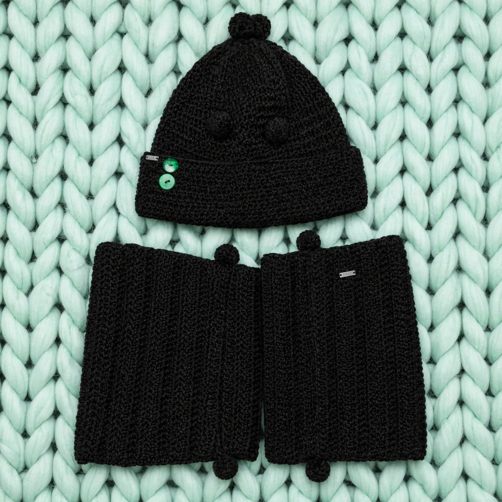 Conjunto completo Noir Wrap — gorro con pompones y bufanda extra larga crochet negro sobre fondo menta — LIA.G
