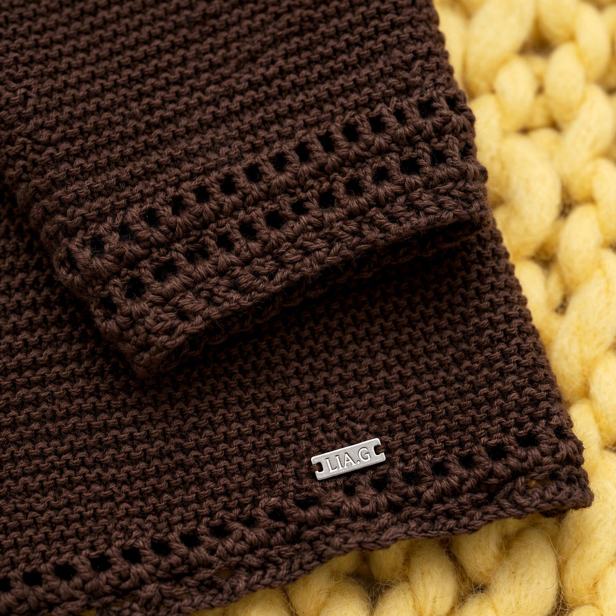 Detalle puños y bajo con remate calado tipo ojal y etiqueta textil LIA.G — Suéter Chocolate