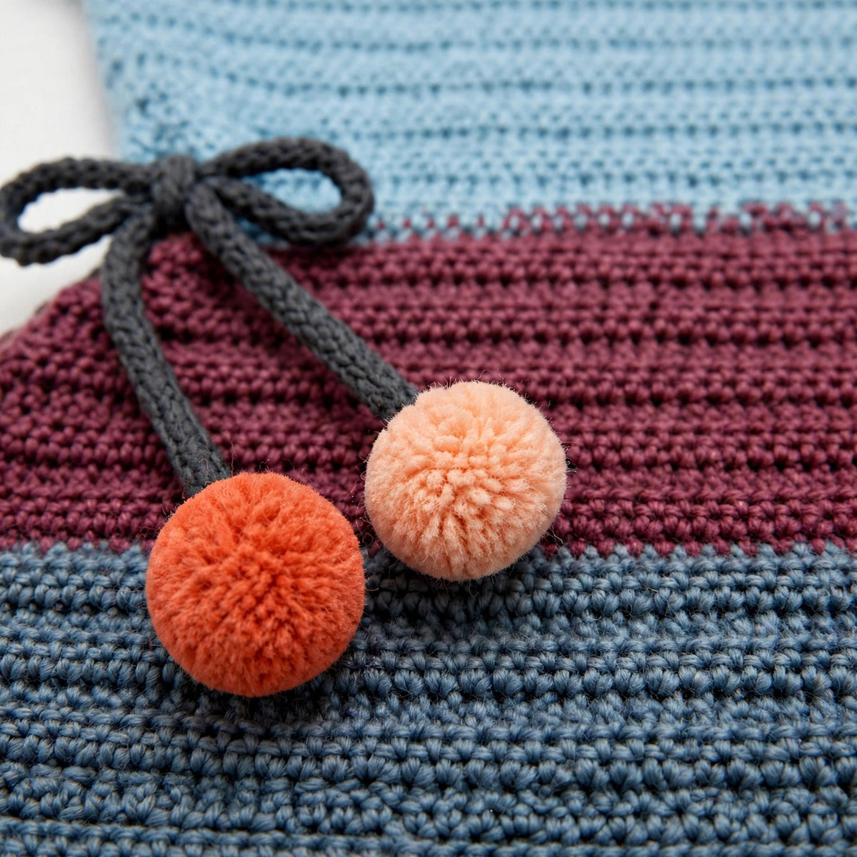 Detalle cordones laterales con lazo y pompones dobles blusa crochet Ocaso
