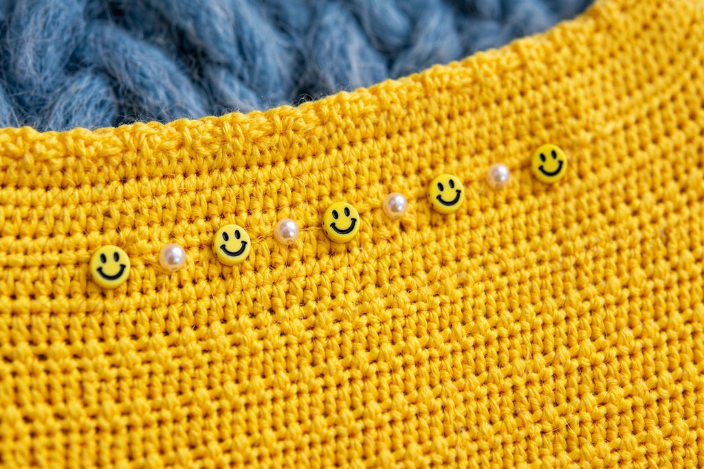 Detalle cuentas carita sonriente y perlas bajo el cuello — Top Crochet Amarillo LIA.G
