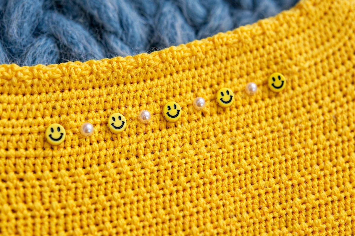 Detalle cuentas carita sonriente y perlas bajo el cuello — Top Crochet Amarillo LIA.G